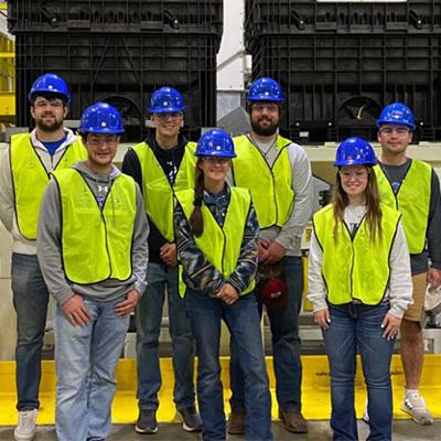 students pose in safety vests at a factory tour event